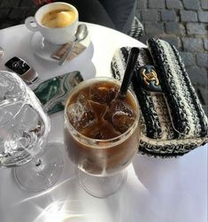 a table topped with glasses and drinks on top of a white tablecloth covered table