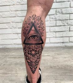 a man's leg with an all seeing eye tattoo on it