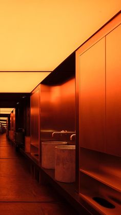 an empty hallway with urinals and sinks in it