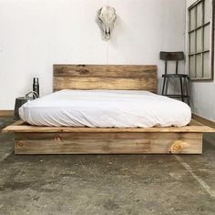 a bed made out of wood with a cow skull on the wall