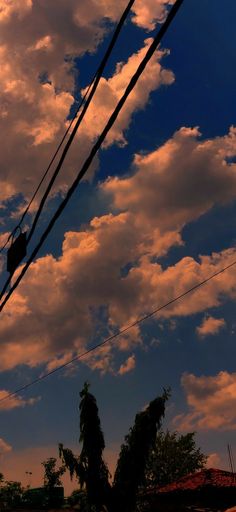 the sky is filled with clouds and power lines