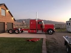 a red semi truck parked in front of a house