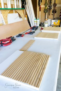 several pieces of wood sitting on top of a white table next to tools and supplies