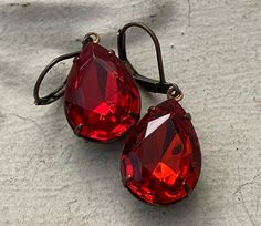 Vintage Light Siam Ruby Red Earrings. Ear wires are new and nickel free. The rhinestones are vintage. If you prefer a different ear wire than the one pictured, please state your preference in the message box at checkout. Your purchase will arrive safely packaged ready for gift giving or a treat for yourself. All purchases will be sent USPS Ground Advantage with tracking and delivery confirmation. Length 1 3/8 inches Vintage Glass Stone 18mmx 13mm Teardrop Thank you for visiting! Enter our shop here www.crowandcompany.etsy.com Red Rhinestone Earrings, Birthstone Earrings, Earrings Ear, Red Earrings, Message Box, Birthstone Earring, July Birthstone, Red Rhinestone, Earrings Vintage