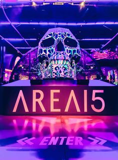 the sign for area 5 is lit up with neon lights and a large skull head