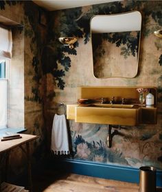 a sink and mirror in a room with floral wallpaper on the walls above it