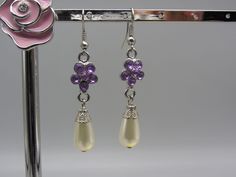 Pretty Dangle Pierced earrings with pretty purple stones arranged in a flower shape with a pearl shaped dropper. Your beautiful earrings will be carefully wrapped and packaged with love. Purple Pearl Earrings Gift, Purple Pearl Earrings As Gift, Purple Pearl Earrings For Gift, Purple Pearl Earrings For Pierced Ears As A Gift, Purple Flower Charm Earrings, Elegant Purple Teardrop Flower Earrings, Purple Teardrop Pearl Drop Earrings, Purple Dangle Pearl Earrings As Gift, Elegant Lavender Flower Earrings With Ear Wire