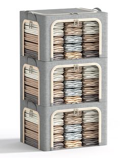 three stacks of folded clothes are stacked on top of each other in an organized storage unit