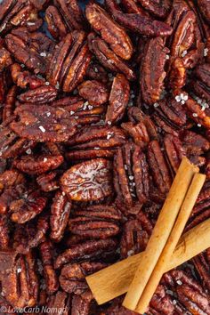 a pile of pecans next to a wooden spoon