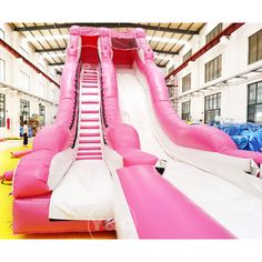 an inflatable water slide with pink and white slides