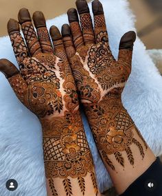 two hands with henna designs on them