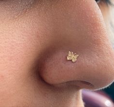 a woman's nose with a tiny gold butterfly on it