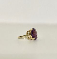 Color yourself happy with this passionately purple solitaire ring! The amethyst is faceted in a checkerboard fashion making it sparkly and peppy! Since purple is the color of royalty you will definitely feel like the queen when you wear this. Metal: 14 Karat yellow gold Gemstone: Round amethyst measuring approximately 15.00mm in diameter. The amethyst is faceted in a checkerboard style pattern and is considered to be moderate to dark in hue. All rings come with one free sizing...To size the ring Faceted Purple Amethyst Ring For Formal Occasions, Formal Faceted Purple Amethyst Ring, Fine Jewelry Diamond Cut Oval Amethyst Ring, Fine Jewelry Amethyst Ring With Diamond Cut, Fine Jewelry Oval Amethyst Ring With Diamond Cut, Formal Faceted Amethyst Ring, Faceted Purple Amethyst Ring Fine Jewelry, Purple Faceted Ring For Formal Occasions, Formal Faceted Purple Ring