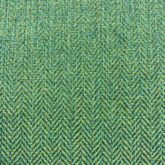 an upholstered green and yellow fabric textured with small diamond pattern, closeup