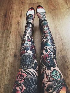 the legs and ankles of a woman with tattoos on her body are covered in flowers