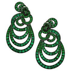 This unique pair of earrings fuse elegance and whimsical design. Set in 18 karat gold plated with black rhodium, showcasing 280 round cut emeralds, weighing approximately 18 carats. Framed with layers of circles cascading into ovals, arranged to exhibit the brilliance and richness of each emerald. This magnificent pair weighs a total of 35.0 grams. Each earring measures 12.11 mm, tapering to 33.10 mm in width, and 61.11 mm in length. An eye-catching statement piece. Our pieces are all accompanie Gold And Emerald, Black Stud Earrings, Whimsical Design, Emerald Earrings, Black Rhodium, Design Set, Style Earrings, Selling Jewelry, Luxury Jewelry