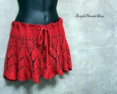 This summer unlined mini skirt is crocheted from 100% acrylic threads. This skirt is crocheted for the beach and looks lacy. It is expanded to the bottom and looks very original. The skirt also has a drawstring with plastic beads on the both ends that holds it on the waist or hips. You can wear it on the beach over a swimsuit on your hips and this will give a special charm to your look. Also you can order this skirt in a BLUE color. Available in four US sizes: XXS, XS, S, M, L, XL Size: XXS hips Casual Crochet Beach Skirt, Casual Crochet Skirt For Beach, Handmade Mini Skirt For Summer, Fitted Red Mini Skirt For Beach, Red Fitted Mini Skirt For Beach, Beach Crochet Mini Skirt, Summer Festival Crochet Skirt, Crochet Mini Skirt For Beach, Crochet Mini Skirt For Beach In Summer