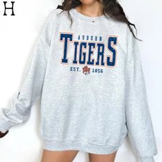 a woman wearing a sweatshirt with the words auburn tigers on it