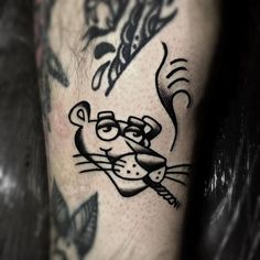 a close up of a person's leg with a cat tattoo on it