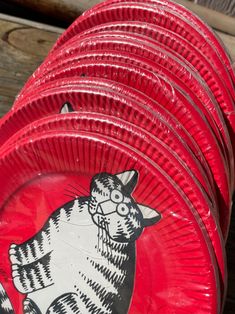 red plates with black and white designs are stacked on top of each other in the shape of a cat