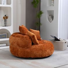 an orange bean bag chair sitting on top of a white rug in a living room