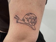 a small snail tattoo on the right side of the arm, it is black and white