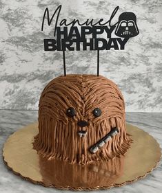 a star wars themed birthday cake with chocolate frosting and a happy face on top