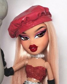 a close up of a doll wearing a red hat and dress with sequins