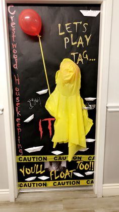 a door decorated with a yellow raincoat and red balloon