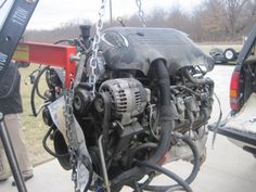 the engine of a truck is being worked on by a man in a black shirt