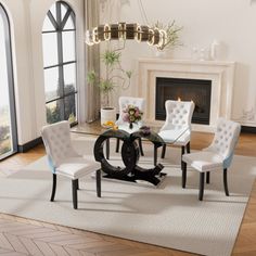 a living room with white chairs and a glass table in front of a fire place