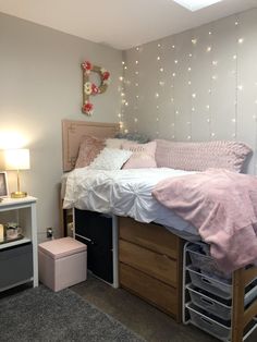 a bedroom with a bed, dresser and lights on the wall