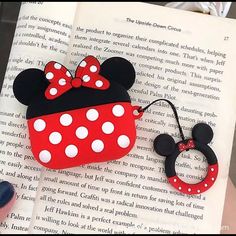 a person is holding up a book with minnie mouse ears on it