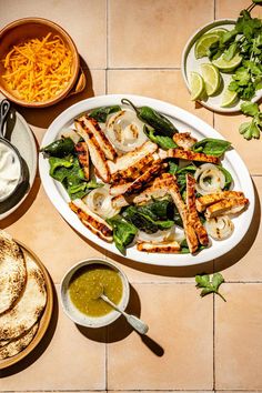 an overhead view of a plate of grilled chicken, spinach salad and pita bread