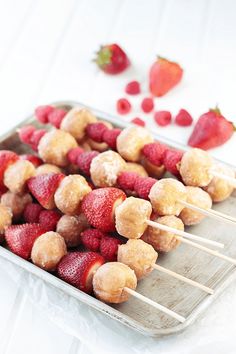 strawberries and other fruits are arranged on skewers