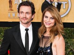 a man and woman standing next to each other on a red carpet