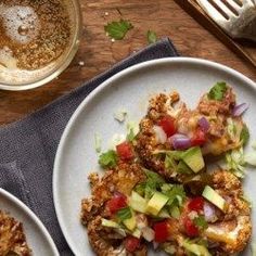 two white plates topped with food next to a cup of coffee and fork on a wooden table