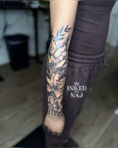 a woman's leg with flowers on it and the words inked naj