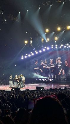 a group of young men standing on top of a stage next to each other in front of a crowd