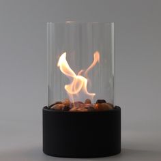 a glass vase filled with rocks and flames