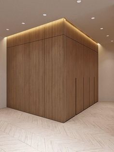 an empty room with wood paneling and lights on the ceiling is lit by recessed lighting