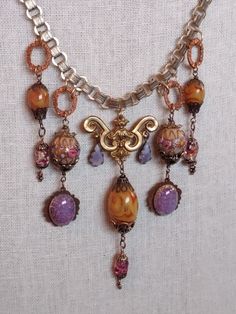 An assemblage bib-style necklace with a Victorian sensibility. The central pendant is a brass ormolu from a Victorian clock that was dated on the clock face, 08 December 1884. Suspended from this piece are vintage Czech opal teardrops and a large gold with cranberry swirl Czech bead. This bead came from a 1930s necklace I disassembled. Accompanying pendants are vintage Venetian wedding cake lampwork beads, confetti foil vintage Czech glass, Czech opal glass cabochons mounted on vintage brass com 1930s Necklace, Victorian Clock, Victorian Clocks, Victorian Watch, French Circus, Czech Beads Jewelry, Venetian Wedding, Jewelry Repurposed, Brass Components