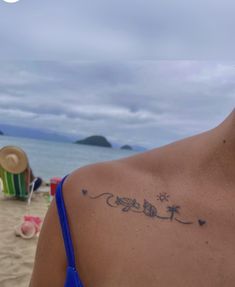 a woman with a tattoo on her back at the beach