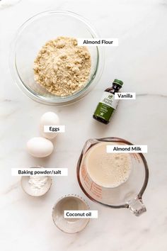 ingredients needed to make an egg muffin recipe on a marble counter top, including eggs, flour, butter, and coconut oil