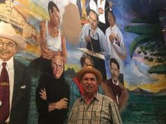 a man is standing in front of a mural