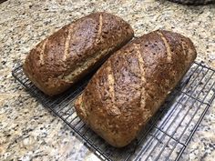 two loaves of bread cooling on a rack