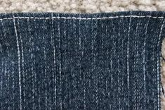 a piece of blue denim with white stitching on the bottom and side of it