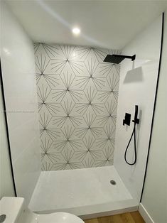 a bathroom with a white toilet sitting next to a walk in shower under a faucet