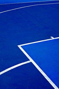 a tennis court with blue and white lines on the ground, as seen from above