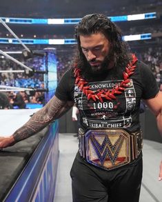 a man with long hair and beard standing next to a wrestling ring